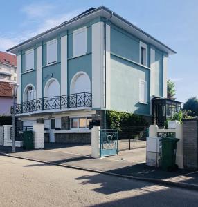 a blue building with a balcony on a street at Residence Louis Quartier Des Lilas in Vittel