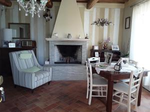 sala de estar con chimenea, mesa y sillas en Villa Rossana en Sassofortino