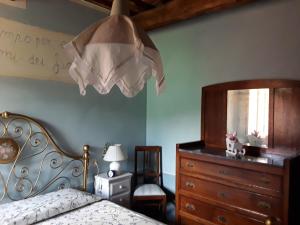 una camera con letto, cassettiera e lampada di Villa Rossana a Sassofortino