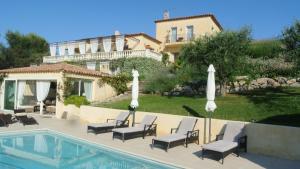 uma piscina com cadeiras e guarda-sóis ao lado de um prédio em Villa Kilauea B&B em Nice