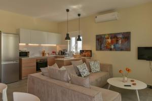 ein Wohnzimmer mit einem Sofa und einer Küche in der Unterkunft Thetis Beach Suites in Kokkinos Pyrgos