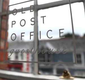 una señal para una oficina de correos frente a un edificio en Old Post Office, en Slane