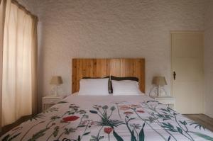 a bedroom with a large bed with a floral bedspread at Quinta do Mirante 1785 in Ponta Delgada