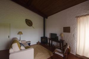 a living room with a white couch and a television at Quinta do Mirante 1785 in Ponta Delgada