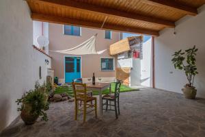 a patio with a table and chairs in a house at La Vecchia Dimora in Marrùbiu