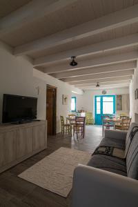 een woonkamer met een bank en een flatscreen-tv bij La Vecchia Dimora in Marrùbiu