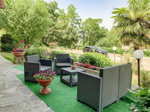 a garden with chairs and a table and flowers at La LocAnna in Serramazzoni