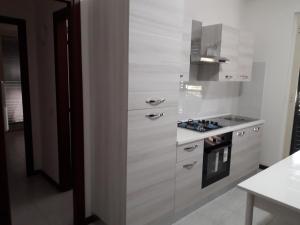 a kitchen with white cabinets and a stove at Casa vacanze Ginevra in Fondachello