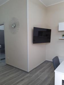 una oficina con una pared y TV de pantalla plana en Villetta 4 Colonne, en Nardò