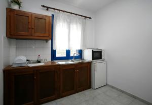 a kitchen with a sink and a refrigerator and a window at Oasis Azolimnos in Azolimnos Syros