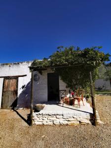 - un bâtiment avec une porte et une table devant dans l'établissement Olive grove cottage, à Koringberg