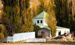 Estancia CristinaにあるEstancia Cristina Lodge - El Calafateの緑の屋根と白い柵の白い家