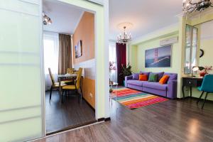 a living room with a purple couch and a dining room at Lakshmi Apartment Novy Arbat 3-bedroom in Moscow