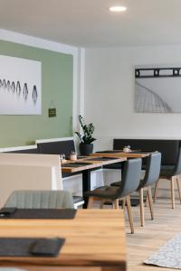 uma sala de jantar com mesas e cadeiras de madeira em KRACHER Guesthouse No 6 em Illmitz