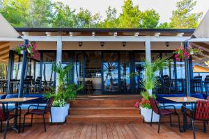 ECUADOR Resort في Zverneci: فناء في الهواء الطلق مع طاولات وكراسي ونباتات