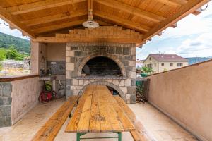 a wooden bench on a patio with a pizza oven at Apartment Livia in Cres