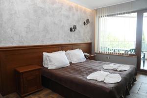 a bedroom with a bed with towels on it at Petrov Family Hotel in Nesebar