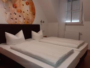 1 Schlafzimmer mit 2 Betten mit weißer Bettwäsche und einem Fenster in der Unterkunft Hotel am Schloss in Dippoldiswalde
