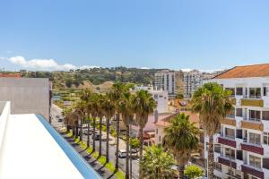 Vue aride d'une ville avec des palmiers et des bâtiments dans l'établissement Hotel Residencial Colibri, à Costa da Caparica