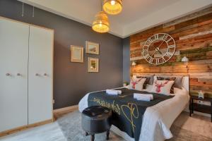 a bedroom with a bed and a clock on the wall at Apartament Fajny Kąt in Ustrzyki Dolne
