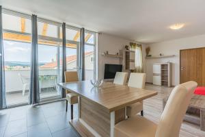 a kitchen and dining room with a table and chairs at Apartment Livia in Cres
