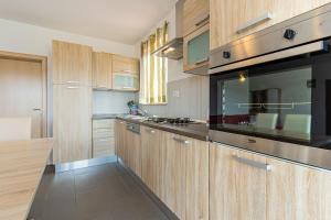 a kitchen with wooden cabinets and a black appliance at Apartment Livia in Cres