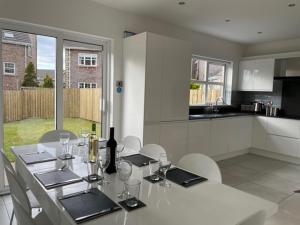 a white table with wine bottles and glasses on it in a kitchen at 14 Millstone Court in Portstewart