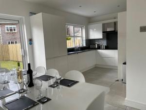 a white table with glasses and a bottle of wine on it at 14 Millstone Court in Portstewart +63 photos