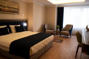 una stanza d'albergo con un letto, un tavolo e delle sedie di Nevi Hotel & Suites Istanbul Taksim a Istanbul