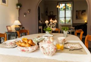 een tafel met croissants en theepotten erop bij Il Était Une Fois Chez Moi in Le Loroux-Bottereau