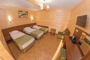 a room with four beds and a television in it at Hotel Anapskiy Briz in Anapa