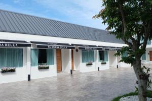 a white building with a black roof at Busaba Bella Hotel in Sichon