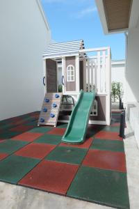 a playground with a green slide on a colorful floor at Busaba Bella Hotel in Sichon
