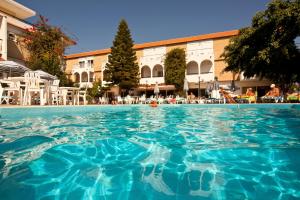 uma piscina em frente a um hotel em Kassandra Hotel em Ialyssos