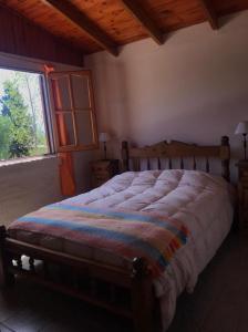 1 dormitorio con 1 cama grande y ventana en Casa Montaña Valle del Sol en Potrerillos