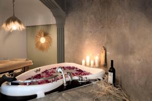 a bathroom with a bath tub with flowers in it at Liman Hotel Gümüslük - Adult Only in Bodrum City