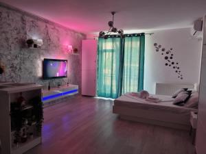 Zimmer mit einem Bett und einem TV. in der Unterkunft Delux Studio Mamaia Nord in Năvodari