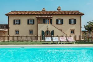 una casa con sillas y una piscina frente a ella en Casa Terzerie, en Braccagni