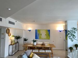 a living room with a table and a couch at Daniel Beachfront in Herzliya B