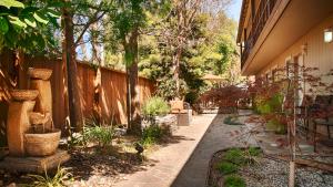 a garden path with a fence and trees at The Zen Hotel Palo Alto in Palo Alto