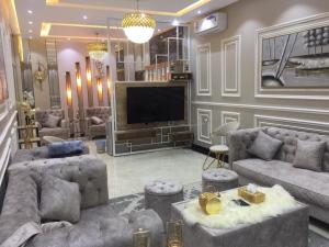 een woonkamer met banken en een flatscreen-tv bij شقق نيام بارك للشقق المخدومه in Rafha