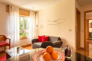una sala de estar con una mesa con naranjas. en Francos Relaxing Apartment by the metro, en Oporto