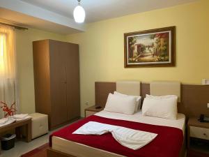 a bedroom with a bed and a painting on the wall at Hotel Relax City Center in Tirana