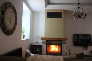 a living room with a fireplace and a clock at A Casa de Pia in Sober