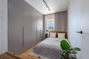 a bedroom with a bed and a window at Apartament Sady # 110 in Olsztyn