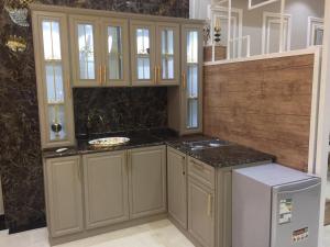 een keuken met grijze kasten en zwarte aanrechtbladen bij شقق نيام بارك للشقق المخدومه in Rafha