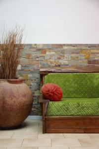 a green bench with two red pillows on it at Le Banana's in Aléria