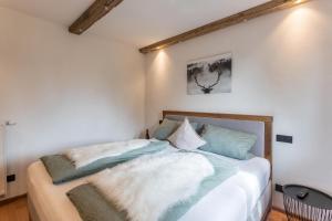 1 dormitorio con 1 cama con almohadas blancas y azules en Fewo beim Nik mit Wanderreitstation, en Höslwang