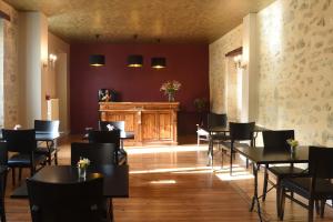 a restaurant with tables and chairs in a room at Le Rodin Bazas in Bazas