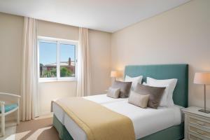 a bedroom with a large bed and a window at Monte Santo Resort in Carvoeiro